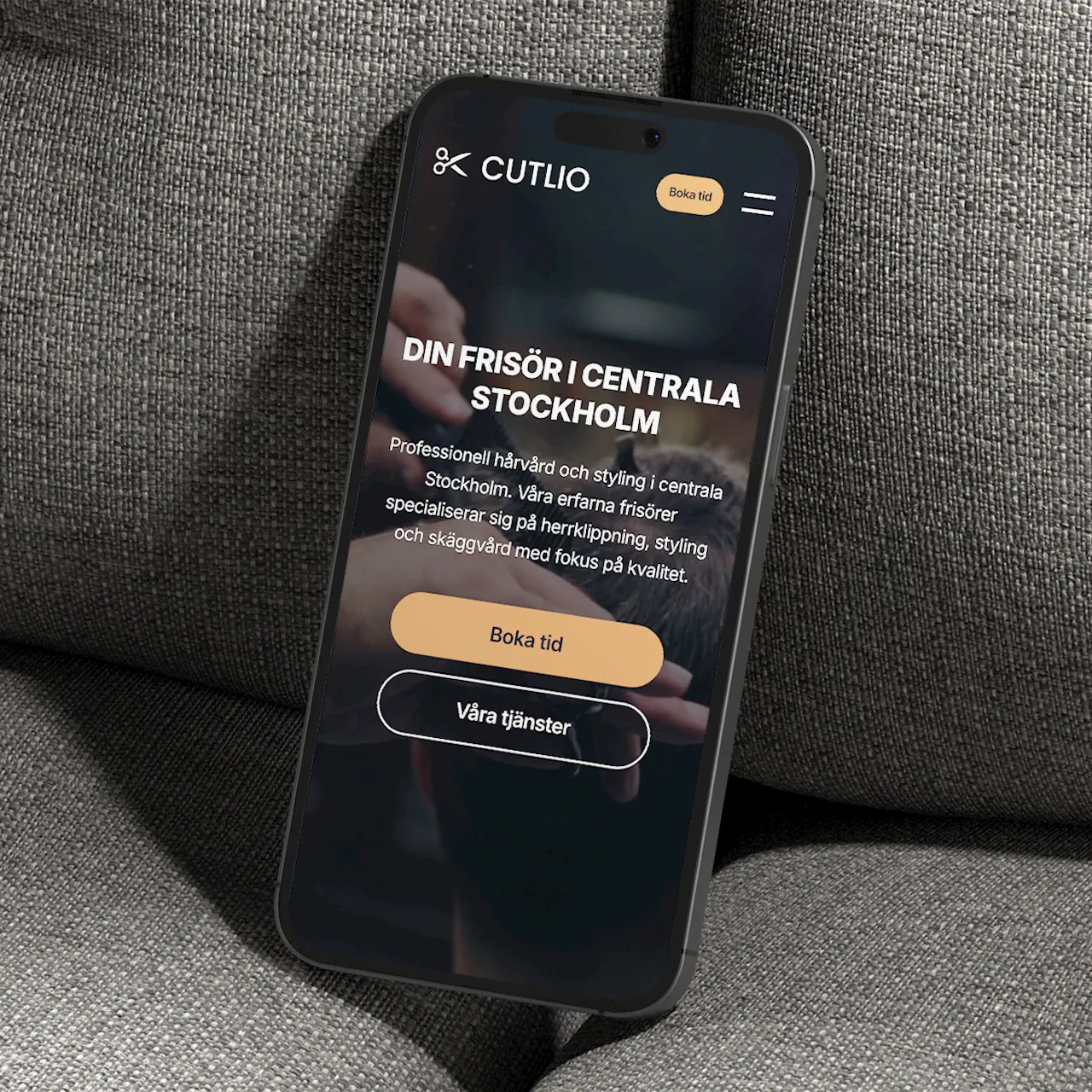 Cutlio frisörsalong hemsida i mobilversion på iPhone med elegant mörk design och tydlig bokningsknapp